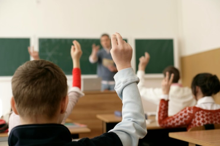 Classroom with hands up