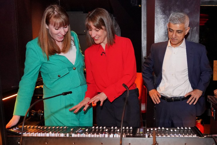 Deputy Prime Minister Angela Rayner (L), Chancellor of the Exchequer Rachel Reeves and Mayor of London Sir Sadiq Khan look at a sound engineer's mixing desk.