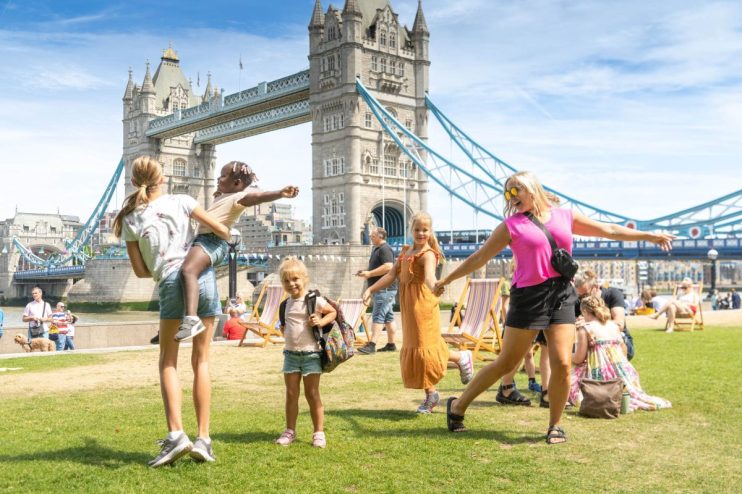 Londoners enjoying sunny spring weather in Potters Fields Park with blue skies and 16-degree temperatures