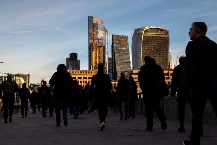 LONDON, ENGLAND - DECEMBER 09: Commuters make their way across London Bridge towards Canada during the morning rush hour on December 9, 2021 in London, England. Last night, the British prime minister announced the introduction of "Plan B" guidance to curb the spread of Covid-19 and its highly transmissible Omicron variant. The measures include mandatory mask-wearing in cinemas and theatres; use of the NHS Covid Pass for nightclubs and large indoor venues; and encouraging people to work from home where possible. (Photo by Chris J Ratcliffe/Getty Images)