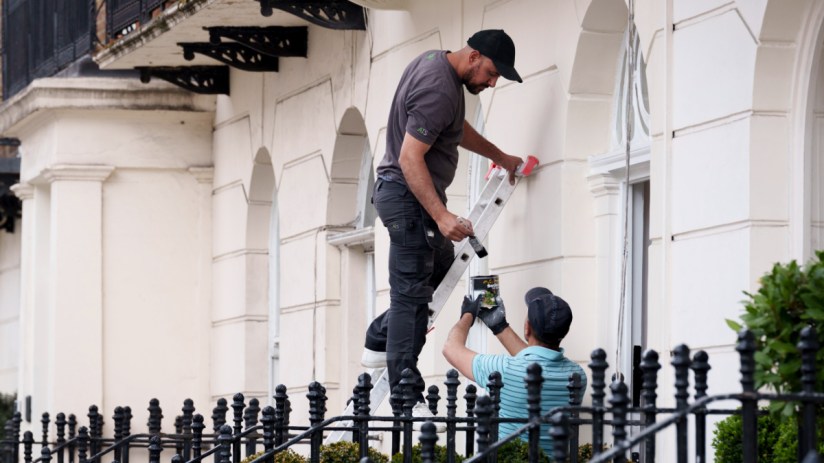 Two painters and decorators paint the underside of a balcony in Belgravia, on 21st May 2025 , in London, England. (Photo by Richard Baker / In Pictures via Getty Images)