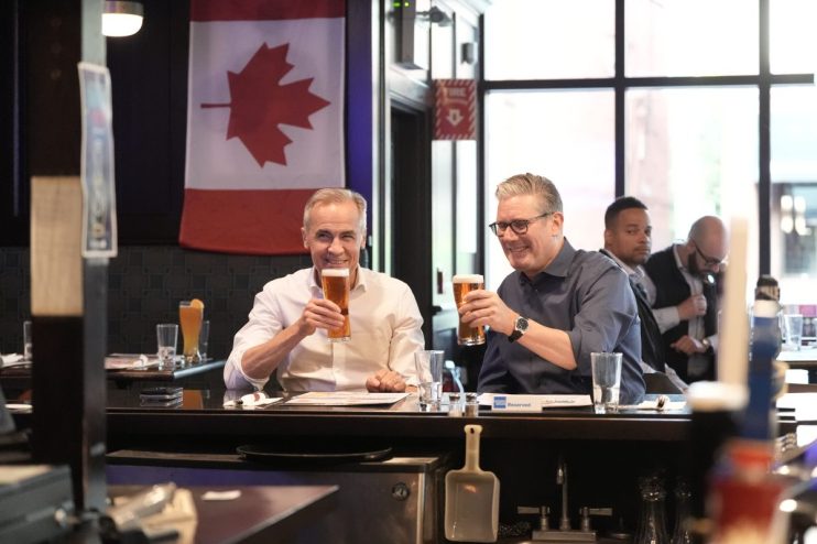 JUNE 14: Prime Minister Sir Keir Starmer and Prime Minister of Canada Mark Carney drinking beer whilst watching a ice hockey game on television between Edmonton Oilers v Florida Panthers at Royal Oak pub ahead of the G7 leaders' summit on June 14, 2025 in Ottawa, Canada. (Photo by Stefan Rousseau - Pool/Getty Images)