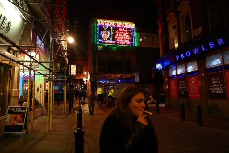 LONDON, ENGLAND - JANUARY 19: A woman walks past the Raymond Revuebar in Soho on January 19, 2015 in London, England. A growing number of campaigners, including Stephen Fry, are pushing developers and representatives of Westminster Council to preserve the area's unique identity, which they fear is being lost as the area is gradually redeveloped. (Photo by Carl Court/Getty Images)