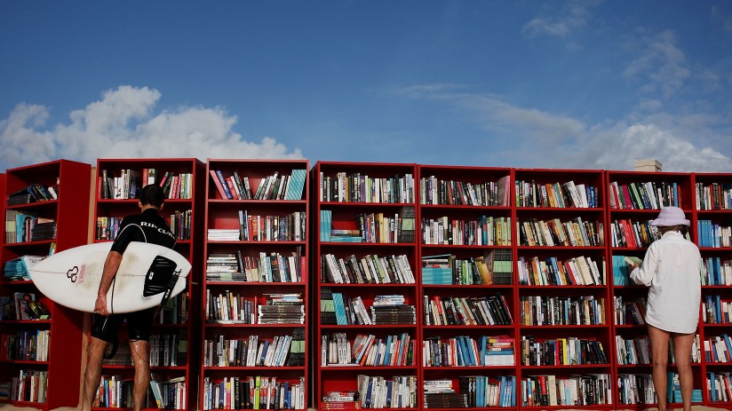 SYDNEY, AUSTRALIA - JANUARY 31: Beach goers select books from 30 red Ikea Billy bookcases lined up to form the world's longest outdoor bookcase to celebrate the 30th birthday of the brand's signature furniture piece, at Bondi Beach on January 31, 2010 in Sydney, Australia. The bookcases were filled with thousands of books which beachgoers can swap for one of their own or make a gold coin donation to buy, with proceeds to The Australian Literacy & Numeracy Foundation. (Photo by Lisa Maree Williams/Getty Images)