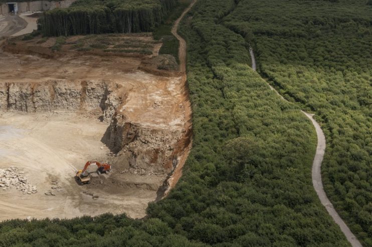 EAST MALLING, UNITED KINGDOM - JULY 06: An aerial view of the Oaken Wood and Hermitage Quarry on July 06, 2023 in East Malling, United Kingdom. Oaken Wood in Kent is a 'Plantation of Ancient Woodland Site', (PAWS), ancient woodland that has been felled and replanted. The woodland is currently under threat from a local quarry run by Gallagher Aggregates Ltd, excavating Kent Ragstone, which is used in construction for restoring old buildings. It is feared that the expansion could lead to the loss of a around 50 hectares of 'precious habitat', home to a wide range of wildlife including dormice, reptiles, butterflies and bats. The woodland lost around 32 hectares, due to the quarries to expansion, in 2013. The Woodland Trust have begun a campaign which has generated more than 7,000 letters of objection. (Photo by Dan Kitwood/Getty Images)