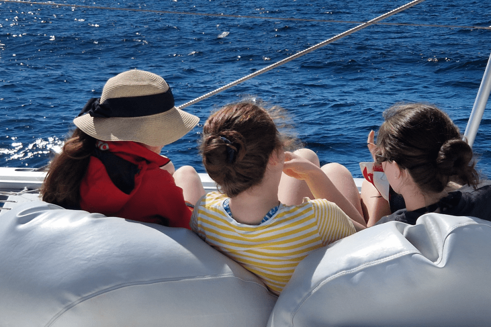 Luxury catamaran sailing in the Bahamas with turquoise waters, sandy beaches, and vibrant marine life in the background