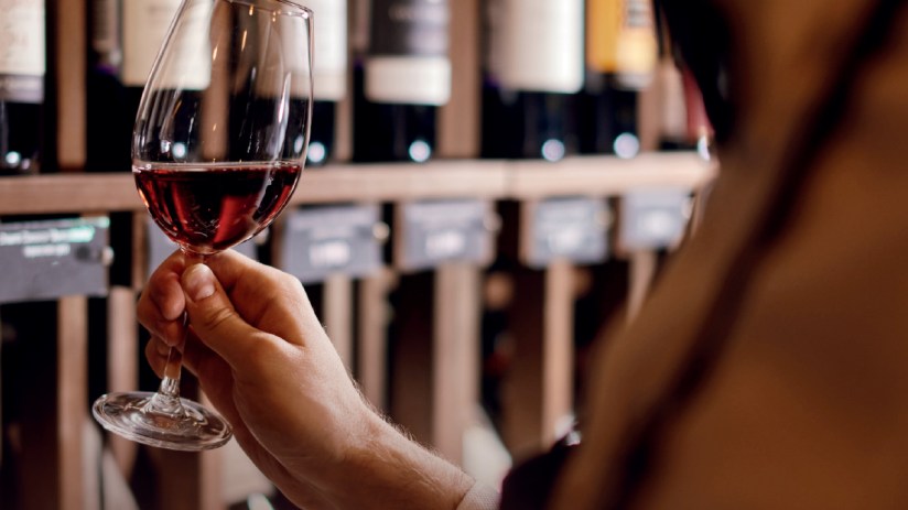 A glass of red wine on a table, symbolizing the ongoing sexism and bigotry in the wine industry highlighted in the article.