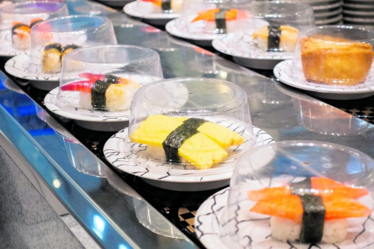 Sushi on conveyor belt in a Thailand restaurant. Shushi Go Round is a famous form of fast food in Asia, also known as sushi train.