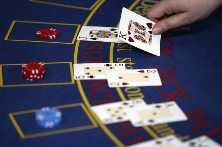 BLACKPOOL, UNITED KINGDOM - FEBRUARY 17: A croupier deals cards on a Black Jack table on February 17, 2006, Blackpool, England. Blackpool and The Fylde College has become the first educational establishment in Britain to offer training and qualifications in gaming. The gaming academy came into existence after changes in the Uk gaming laws and created a skills gap in the industry. Students are trained in every aspect in a casino form running card tables to servicing slot machines. (Photo by Christopher Furlong/Getty Images)