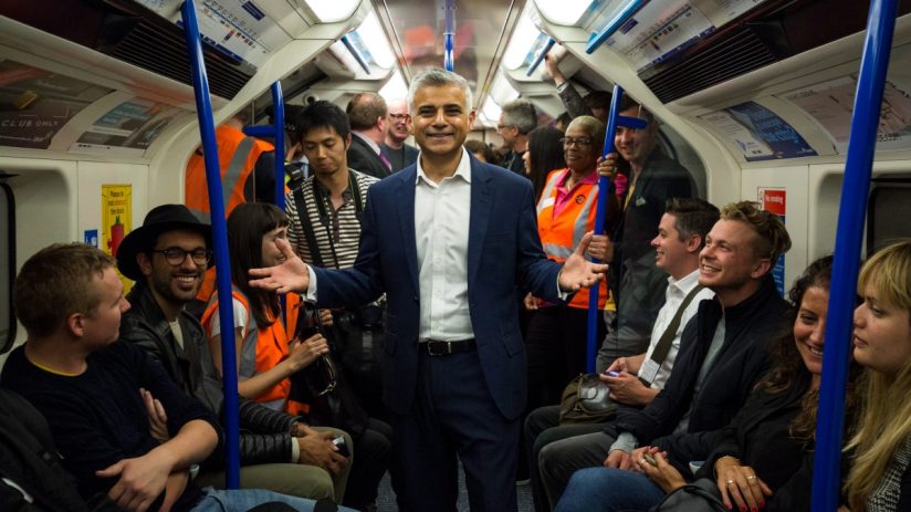 LONDON, ENGLAND - AUGUST 20: London Mayor Sadiq Khan extends his hands as his stand between passengers in the first Night Tube train along the Victoria line on August 20, 2016 in London, England. The London Underground's 24-hour service begins for the first time in its 153 year history. The new Night Tube will see both the Victoria and Central lines run through the night on Fridays and Saturdays. (Photo by Jack Taylor/Getty Images)