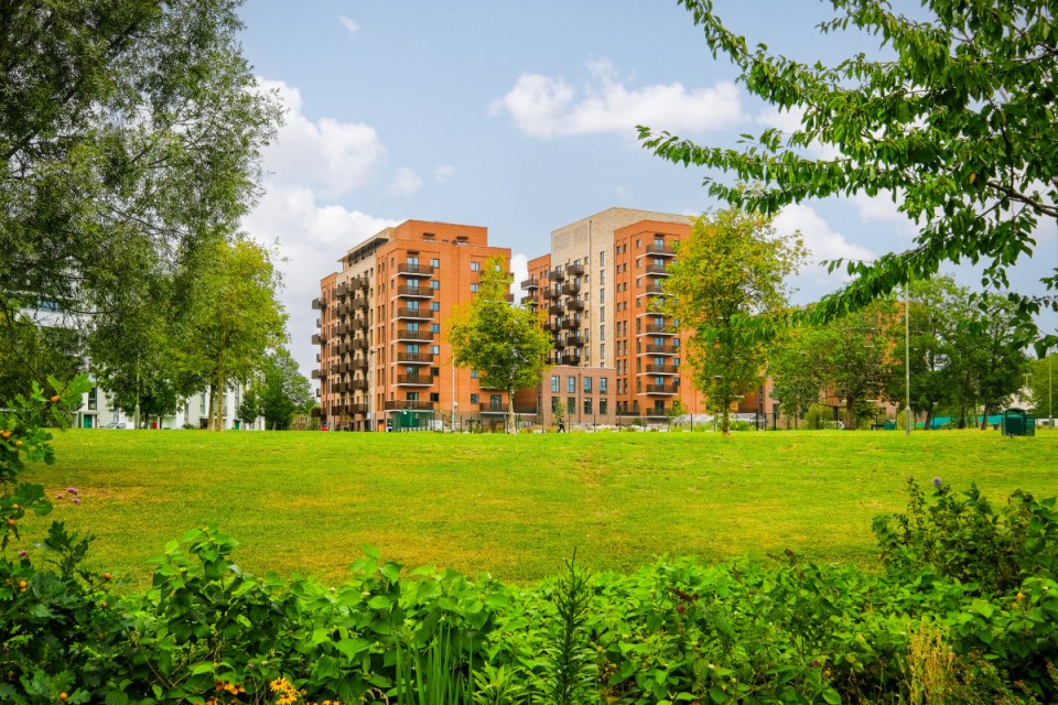 Heybourne Park External view of the development behind some grass.