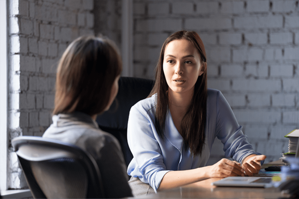 Professional discussing MBA sponsorship with employer in office setting, career progression and financing options in focus