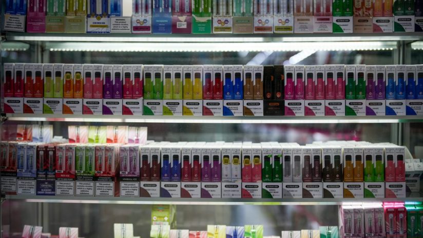 Government official at podium discussing new vape shop regulations amidst ongoing smoking cessation debates