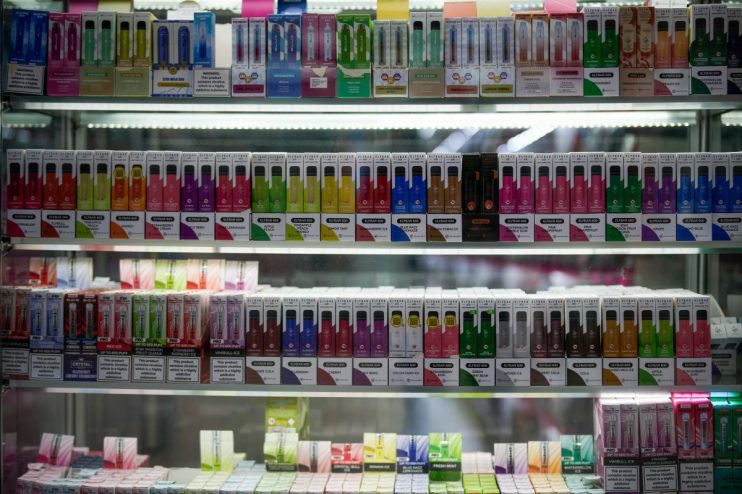 Government official at podium discussing new vape shop regulations amidst ongoing smoking cessation debates