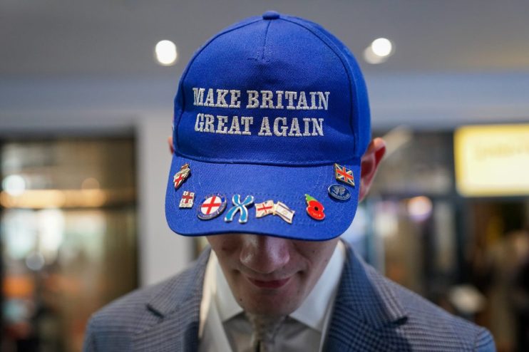 MANCHESTER, ENGLAND - OCTOBER 06: A delegate wears a Make Britain Great Again baseball cap on day two of the Conservative party conference at Manchester Central Convention Complex on October 06, 2025 in Manchester, England. Kemi Badenoch goes into her first conference as party leader with current polling putting the Conservative Party in fourth place behind Reform, Labour and the Liberal Democrats. (Photo by Ian Forsyth/Getty Images)