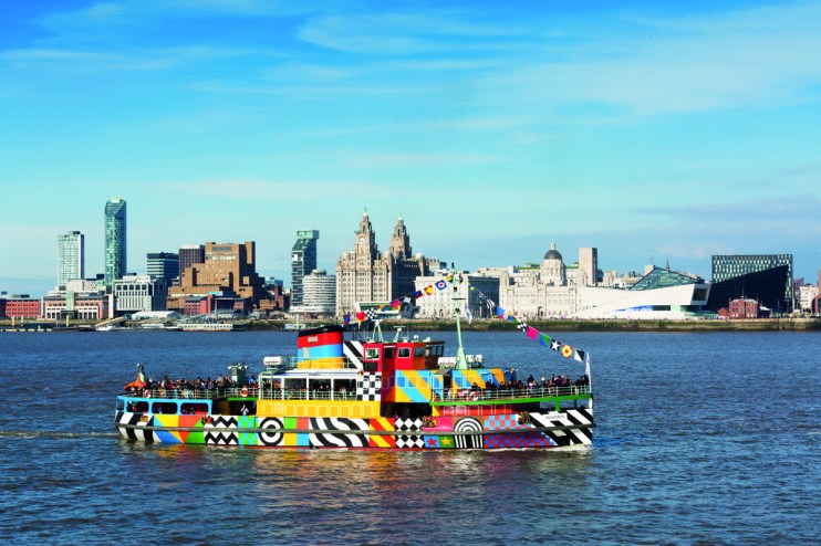 Mersey Ferry Snowdrop adorned in vibrant Dazzle design sailing on the River Mersey against a clear blue sky