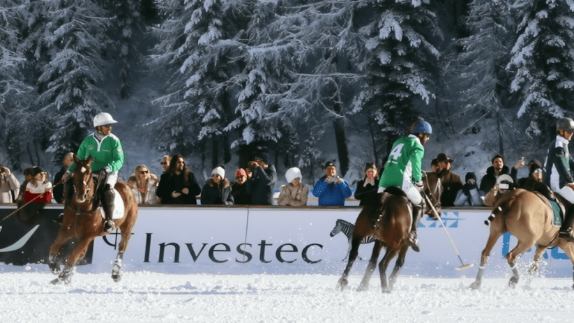Snow Polo World Cup action with players and horses on a snowy field, showcasing dynamic competition and winter sports eleg...