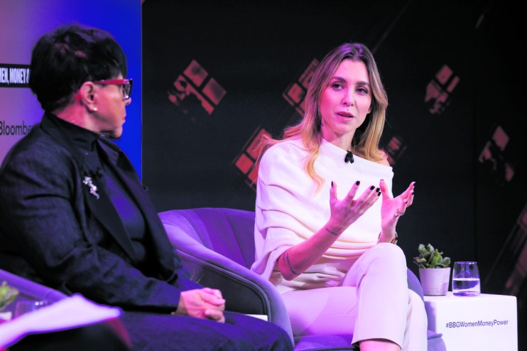 Victoire Cogevina Reynal discussing business strategies at a conference podium, engaging audience in a corporate setting.
