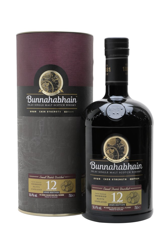 Bunnahabhain 12 Year Old Cask Strength bottle showcasing its rich amber color with a scenic distillery backdrop.