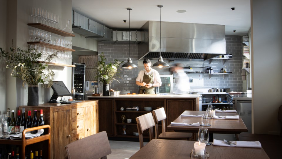 Gorse restaurant open kitchen showcasing chefs preparing dishes, featuring stainless steel appliances and modern decor