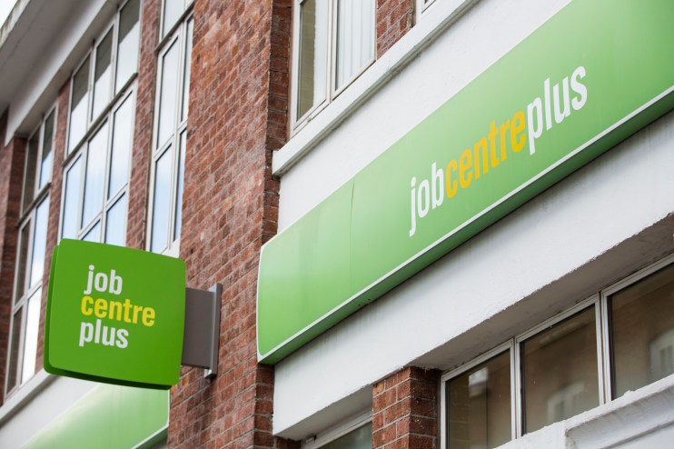 Job seekers enter a busy job centre, engaging with staff, highlighting employment opportunities and workforce development.