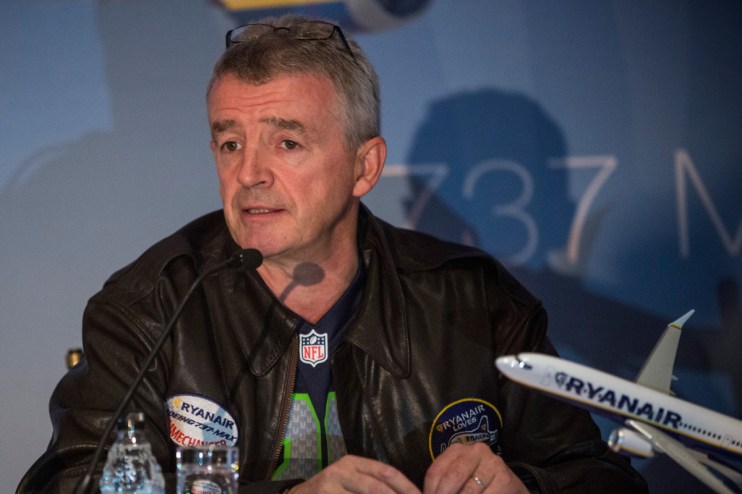 Michael OLeary speaking at a Ryanair press conference, dressed in a suit, discussing the airlines latest business updates
