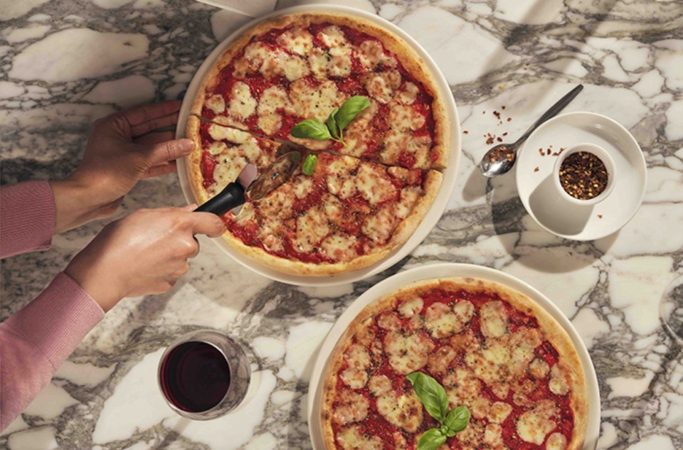 PizzaExpress Classic Margherita with fresh basil and melted mozzarella on a crispy thin crust in a business news setting
