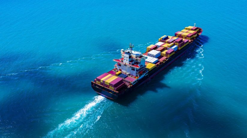 Cargo ship navigating a busy port, showcasing global trade and shipping industry operations in a bustling maritime setting