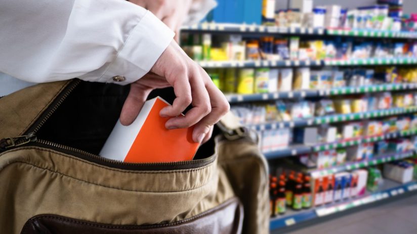 Shoplifting incident in retail store with security camera footage showing suspect concealing merchandise in jacket