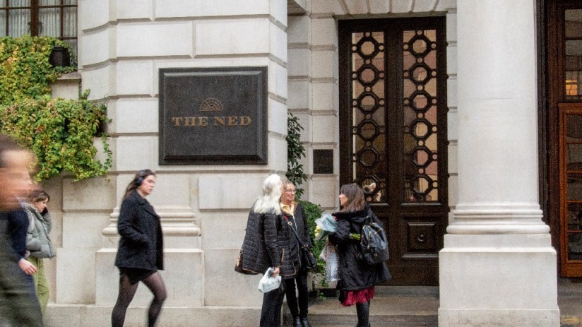 The Ned hotel exterior showcasing its grand architectural design and luxurious entrance in a bustling urban setting