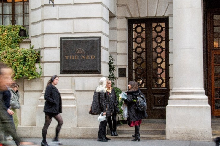 The Ned hotel exterior showcasing its grand architectural design and luxurious entrance in a bustling urban setting