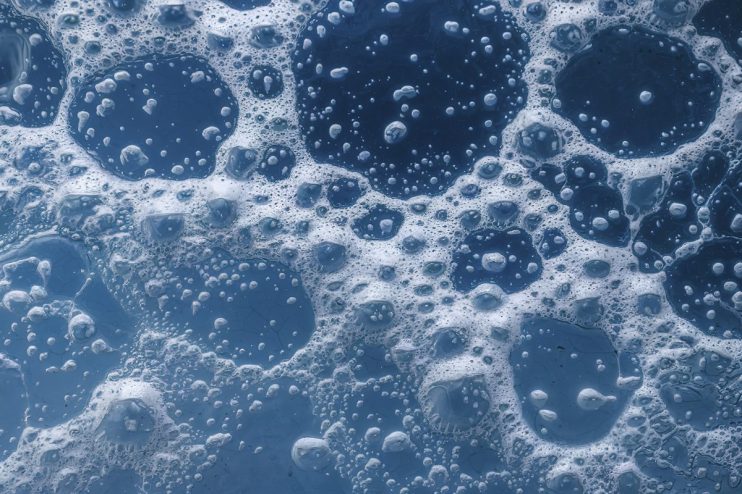Colorful soap bubbles floating against a clear blue sky, symbolizing the fleeting nature of economic bubbles.