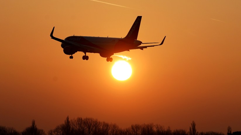 EasyJet aircraft touching down on runway amid clear skies, highlighting travel industry updates and aviation business trends.