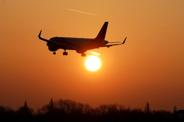 EasyJet aircraft touching down on runway amid clear skies, highlighting travel industry updates and aviation business trends.