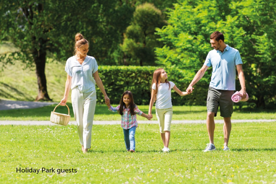 Holiday park guests enjoying outdoor activities during summer vacation, showcasing vibrant nature and family-friendly amen...