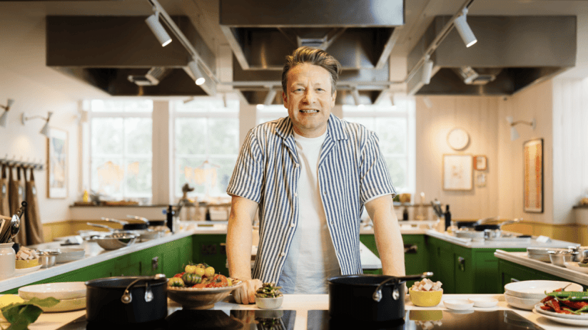 Jamie Oliver showcasing culinary skills in a professional kitchen setting, highlighting his expertise as a renowned chef.
