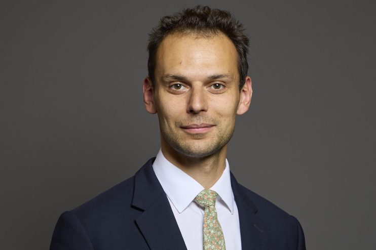 Josh Simons discussing young peoples challenges in the job market at a business conference podium
