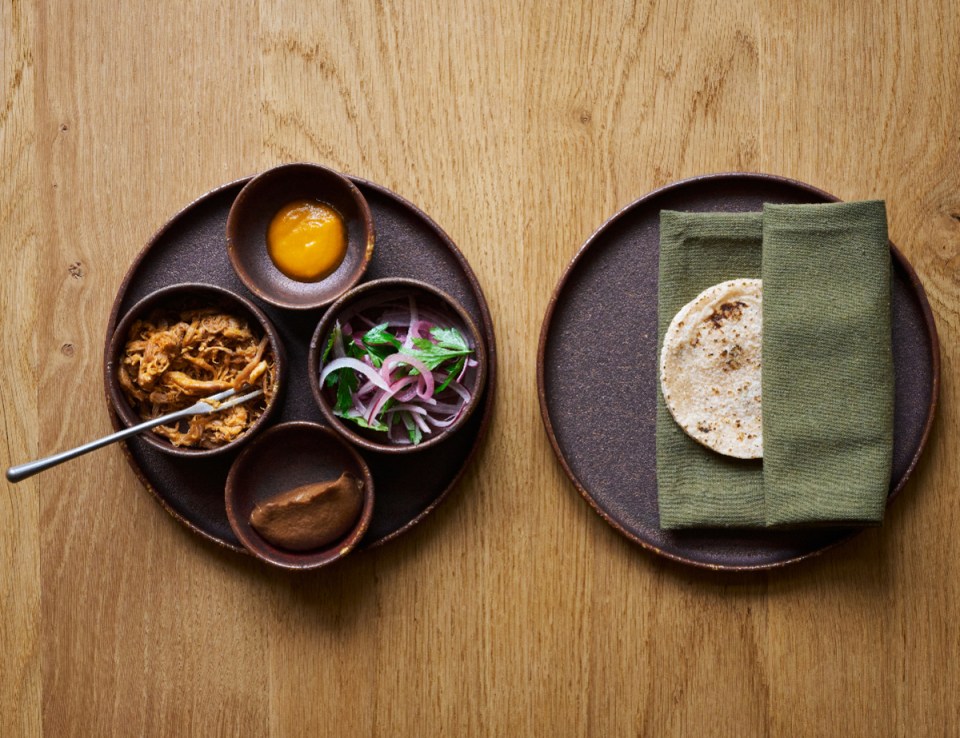 Deliciously arranged mare tacos garnished with fresh herbs and zesty lime slices, showcasing a unique culinary fusion.