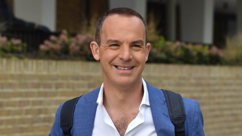 Martin Lewis discussing financial advice on a news segment set, wearing a suit and gesturing with his hands.