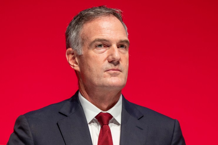 Peter Kyle MP speaking at a press conference, wearing a navy suit and tie, addressing current political issues.