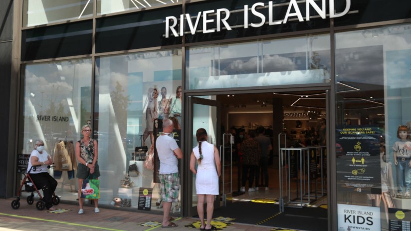 River Island store exterior showcasing stylish autumn fashion display in vibrant urban shopping district