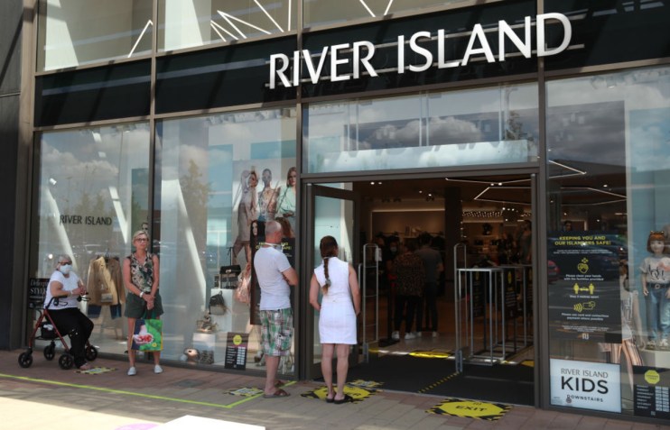River Island store exterior showcasing stylish autumn fashion display in vibrant urban shopping district