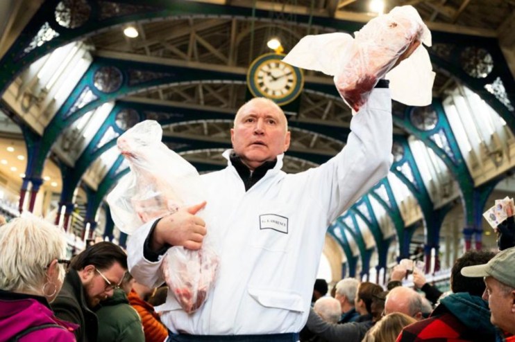 Smithfield meat market auction with bustling crowd, showcasing various meat cuts and enthusiastic bidders in a lively setting