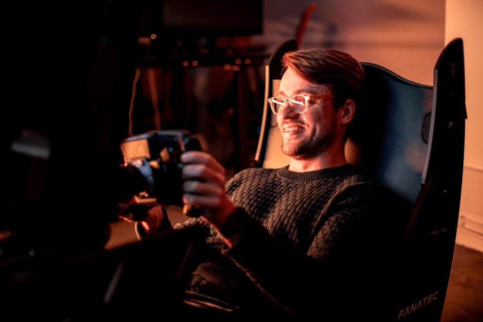Track Titan founder Max Teichert engaged in intense sim racing, showcasing advanced driving simulation technology.
