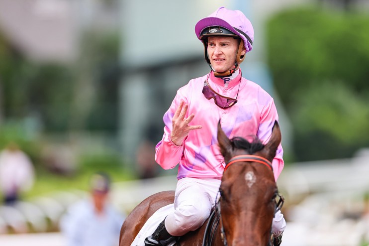 Zac Purton in action during a horse racing event, showcasing his skills as a top jockey, wearing racing attire and helmet
