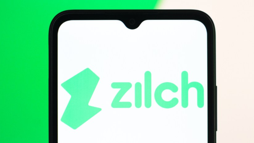Zilch logo on a modern office building facade reflecting a clear blue sky, symbolizing innovation and corporate presence.