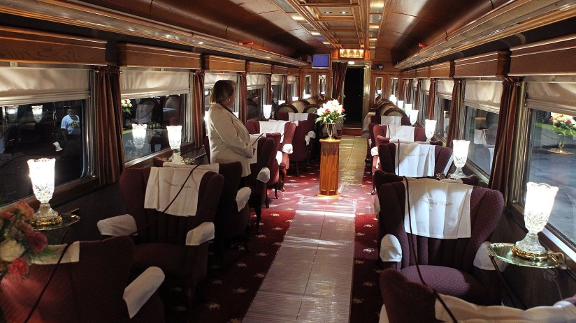 Opulent interior of a luxury train, featuring plush seating, elegant decor, and scenic window views, highlighting premium ...