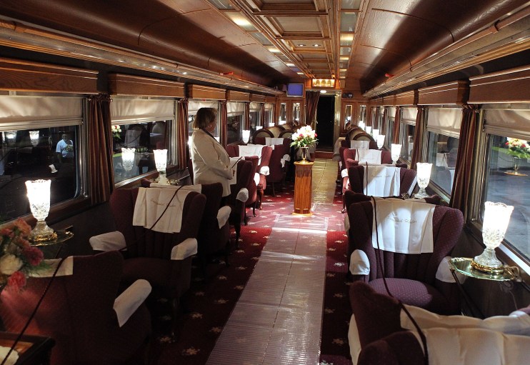 Opulent interior of a luxury train, featuring plush seating, elegant decor, and scenic window views, highlighting premium ...