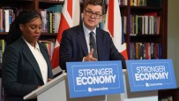 Mel Stride speaking at a press conference, addressing key issues, in a formal setting with a backdrop of the events logo.