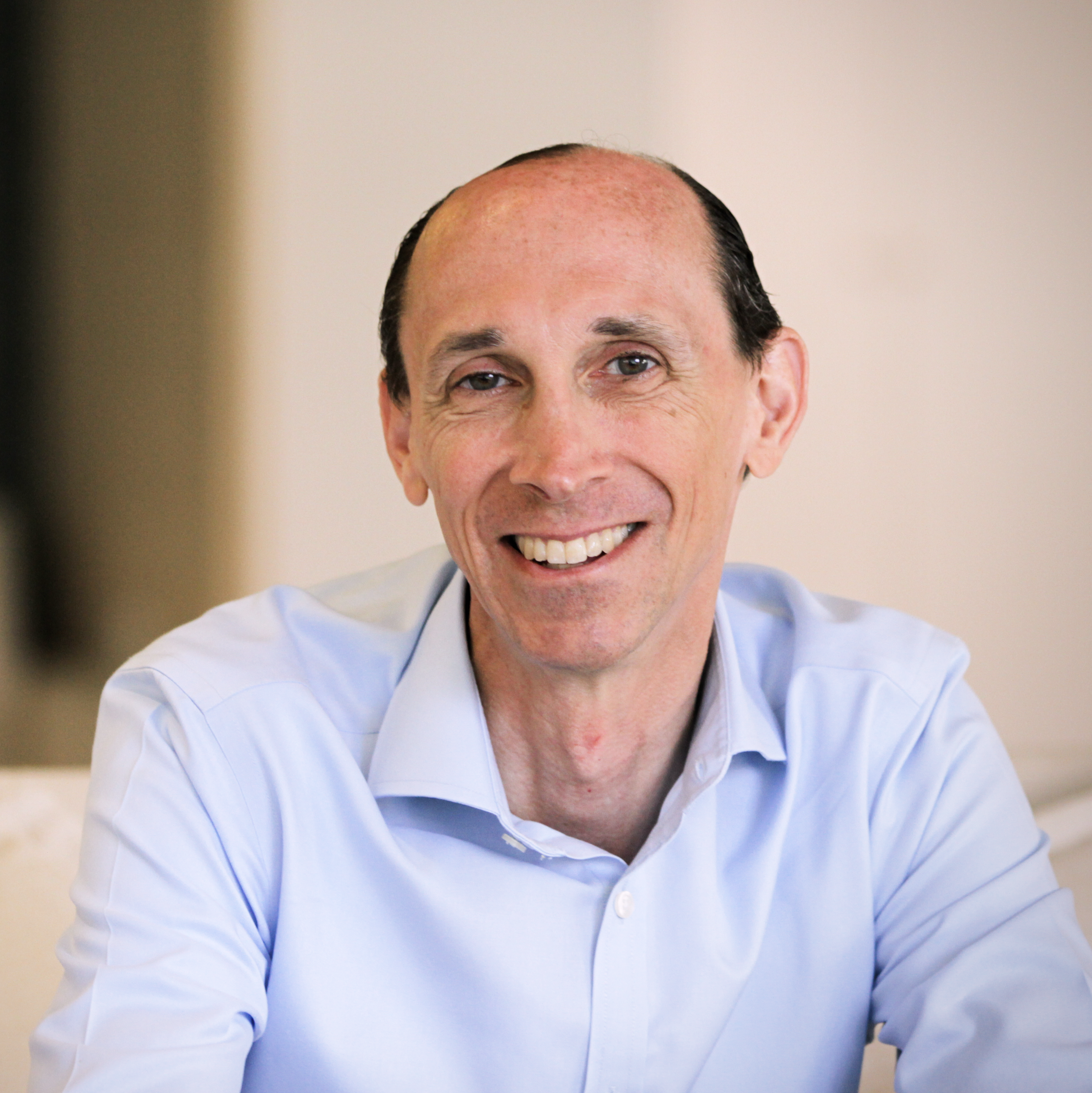 Dana Dunne in a professional setting, likely attending a business meeting or conference, dressed in formal attire.